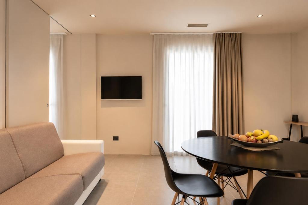 a living room with a couch and a table with a bowl of fruit at Amare Suite & Apartments in Bellaria-Igea Marina