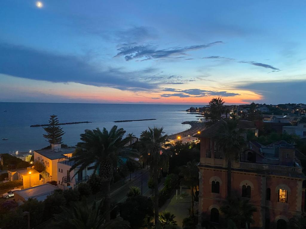 a view of a city with the ocean at dusk at Il Piccolo Cristallo sul Mare in Santa Marinella