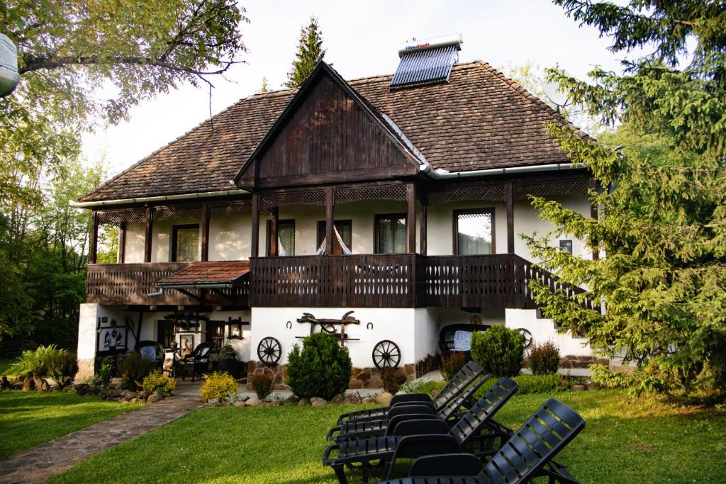 a large house with black chairs in the yard at Behív-Lak in Medişoru Mic