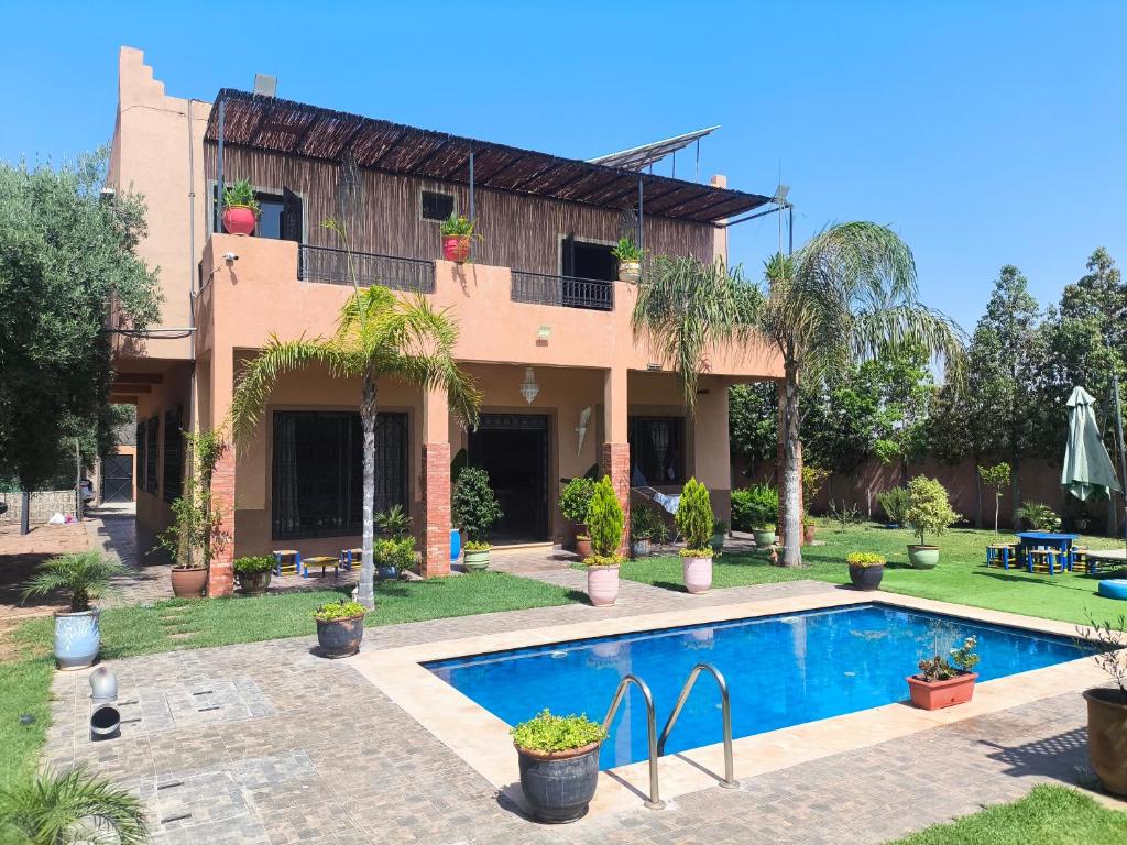 a house with a swimming pool in front of it at Villa khaddouj Marrakech in Marrakesh