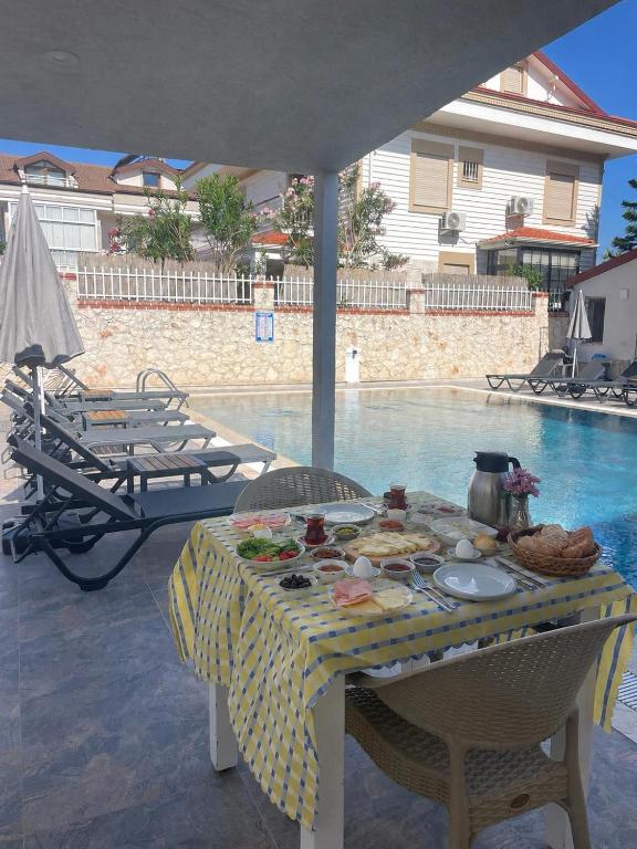 a table with food on it next to a pool at çam otel in Fethiye