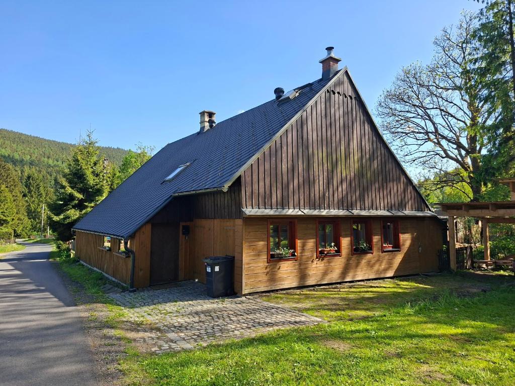 a wooden house with a gambrel roof at Chalupa Rumovka in Ostružná