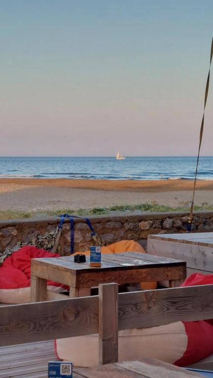 a picnic table on the beach with the ocean in the background at Studio cabine à proximité des plages in Gruissan