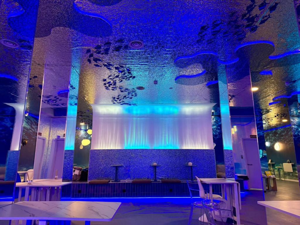 a large room with a large stage with blue lights at The POD Suite Hostel Joaquin Sorolla in Valencia