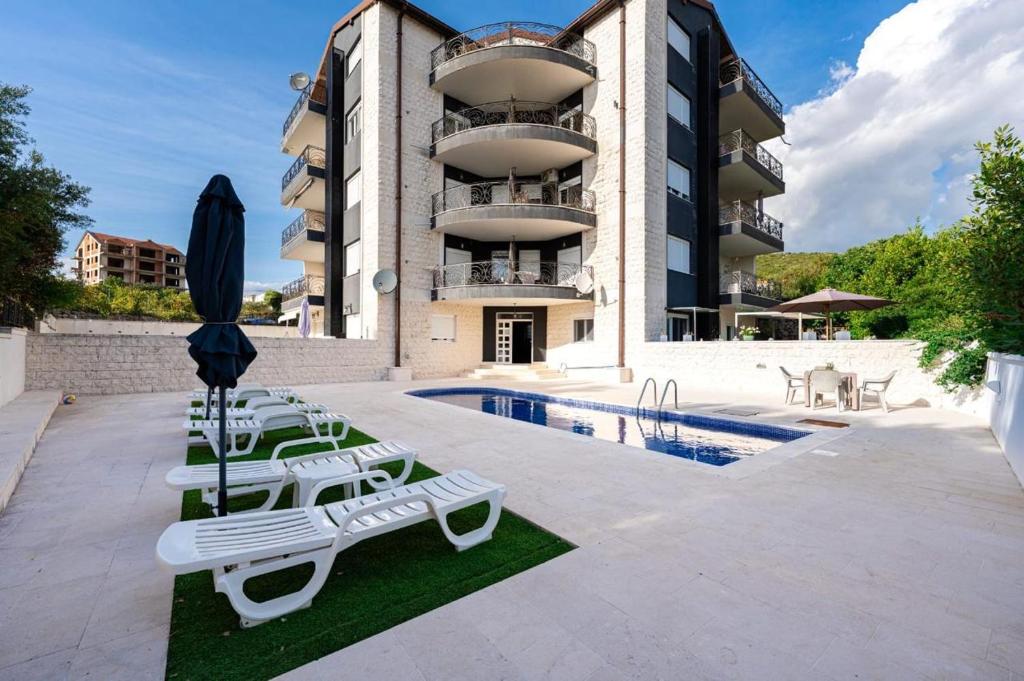 a building with lounge chairs and a swimming pool at Apartment Jasmina in Krimovice