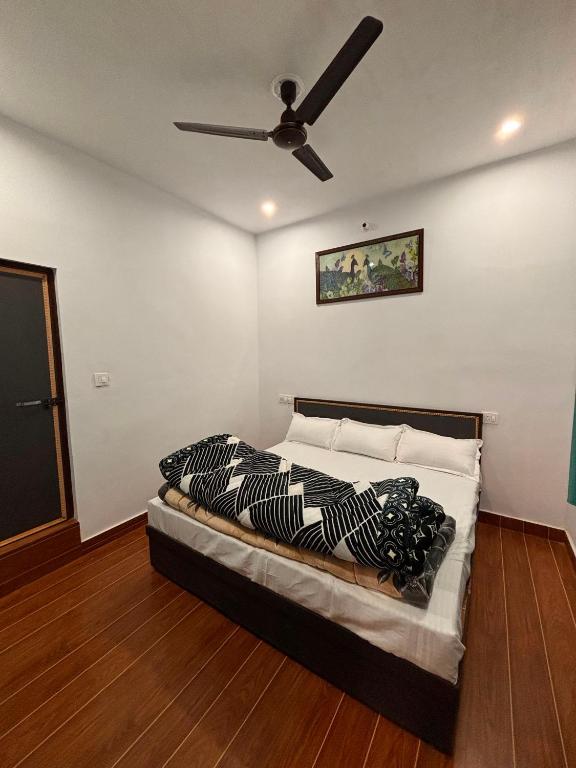 a bedroom with a bed with a ceiling fan at Hotel Anushka palace in Phata