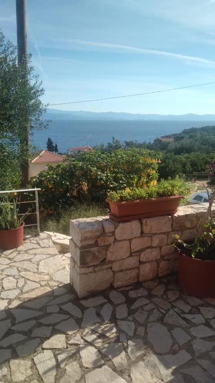 a stone wall with potted plants on top of it at evgenias studio 2 in Gaios