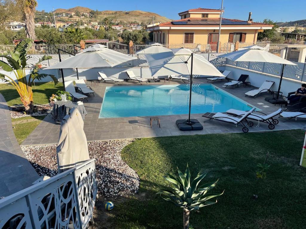 an overhead view of a pool with umbrellas and chairs at Albamaris Guest House in Botricello
