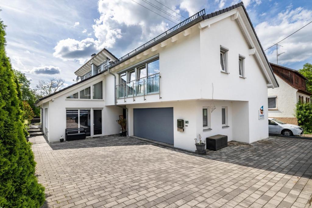 a white house with a driveway at Ferienwohnung Jeannette in Balingen