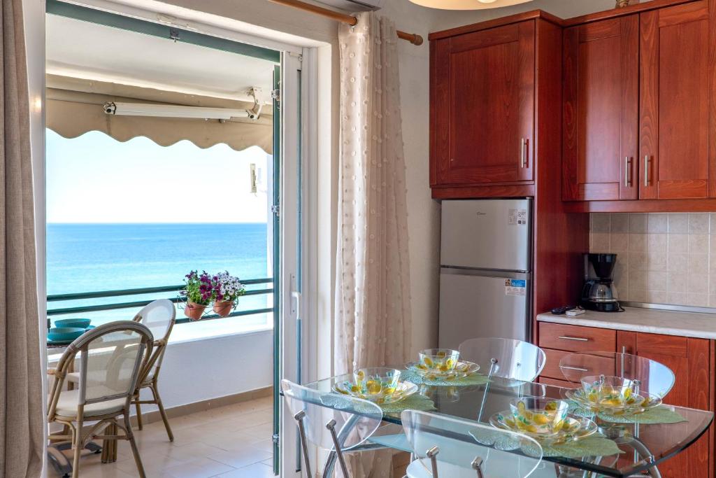 a kitchen with a table and a view of the ocean at Corfu Glyfada Beach Apartment 86 in Glyfada