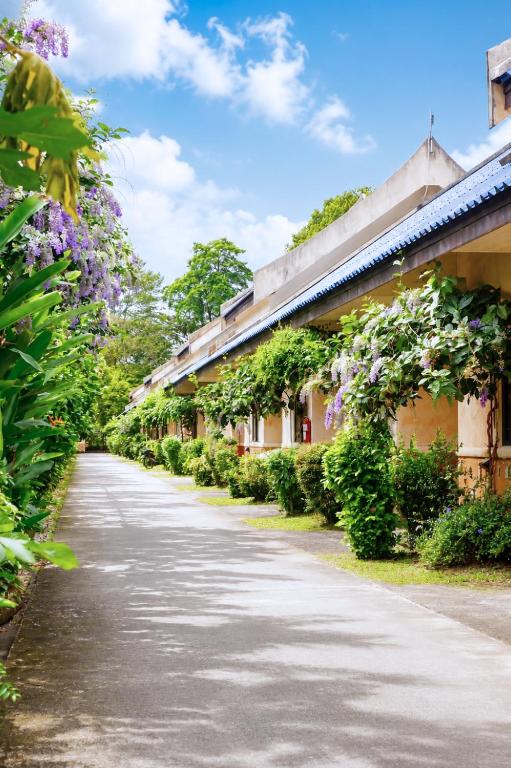 an empty street with flowers on the side of buildings at Chalet De Palm Resort Hatyai in Hat Yai