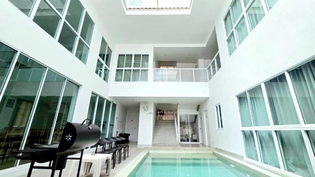a large building with a swimming pool and chairs at The Inn10 Pool Villa Pattaya, Entire 5-9 BR, Please view photos before booking in Pattaya