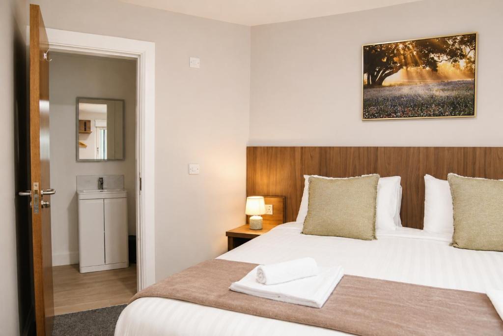 a bedroom with a large bed with a wooden headboard at Coach House Accommodation - Room 3 in Carrick on Shannon
