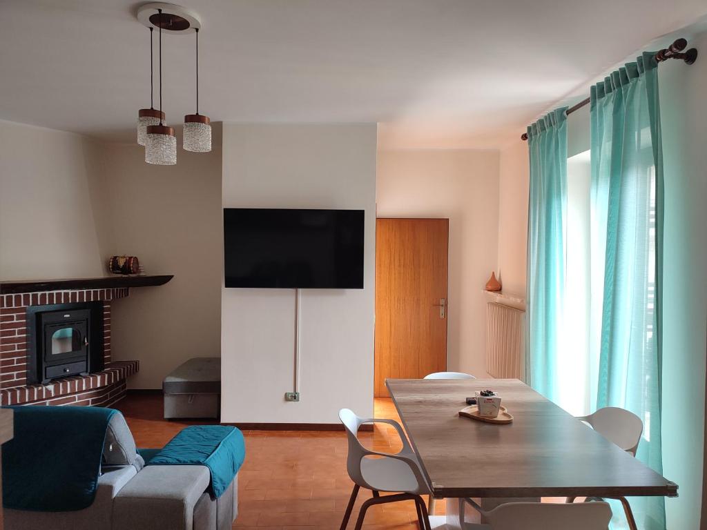 a living room with a table and a tv at Appartamento Verde Lago Ledro in Molina di Ledro