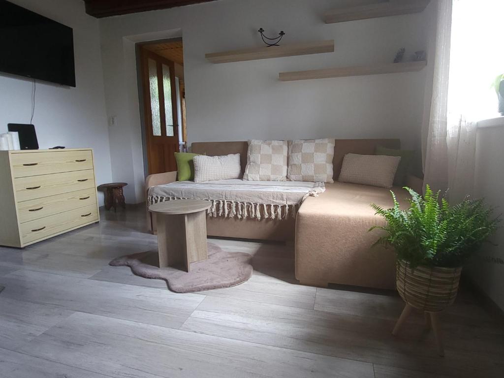 a living room with a bed and a dresser at Chata u lesa in Divec