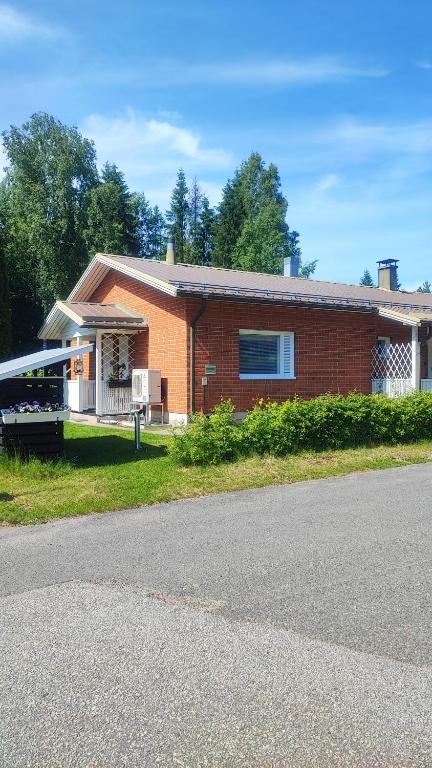 a red brick house on the side of a road at Hartikkalan Apartments in Lappeenranta