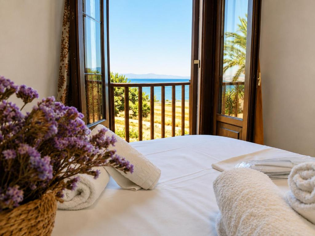 a bedroom with a bed with a view of the ocean at TERRA LEMNIA in Moúdhros
