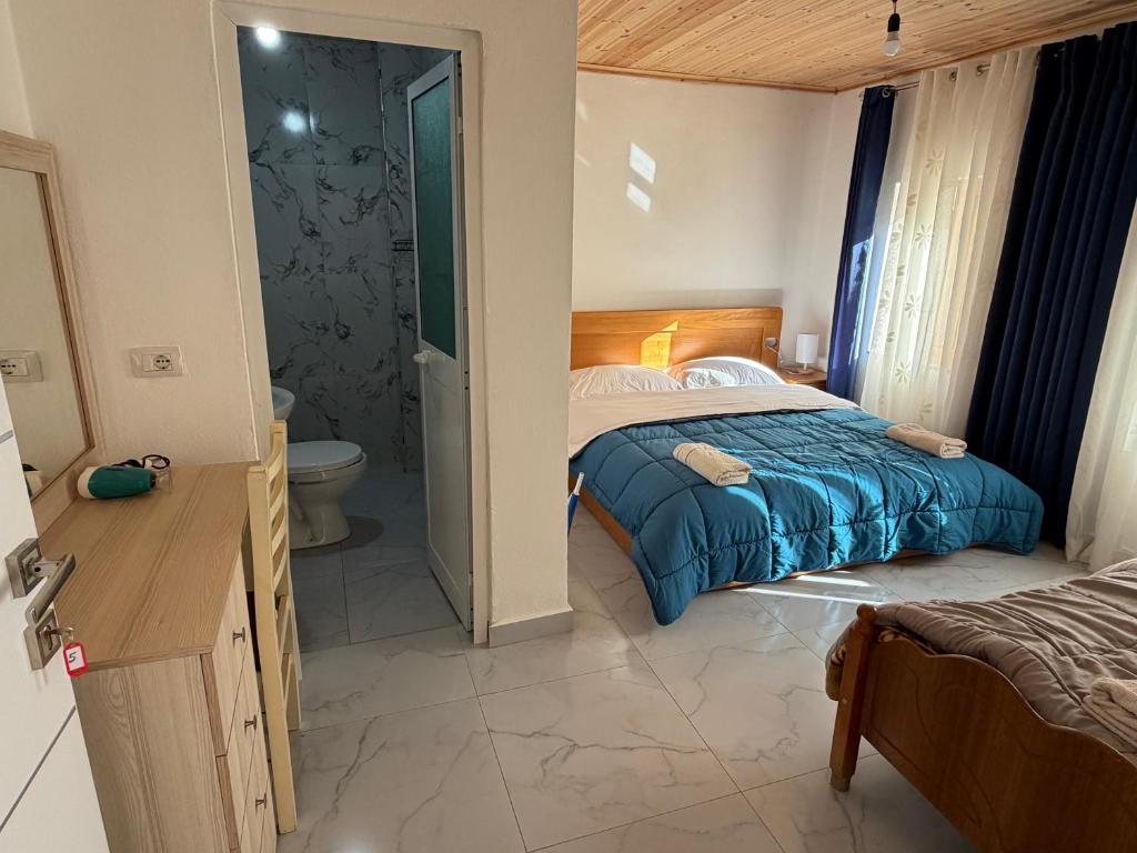 a bedroom with a bed and a bathroom with a toilet at Te Oli Theth in Theth