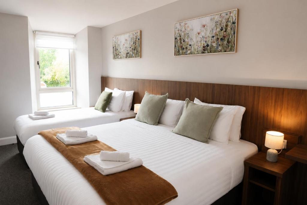 a bedroom with a large white bed and a window at Coach House Accommodation - Room 4 in Carrick on Shannon