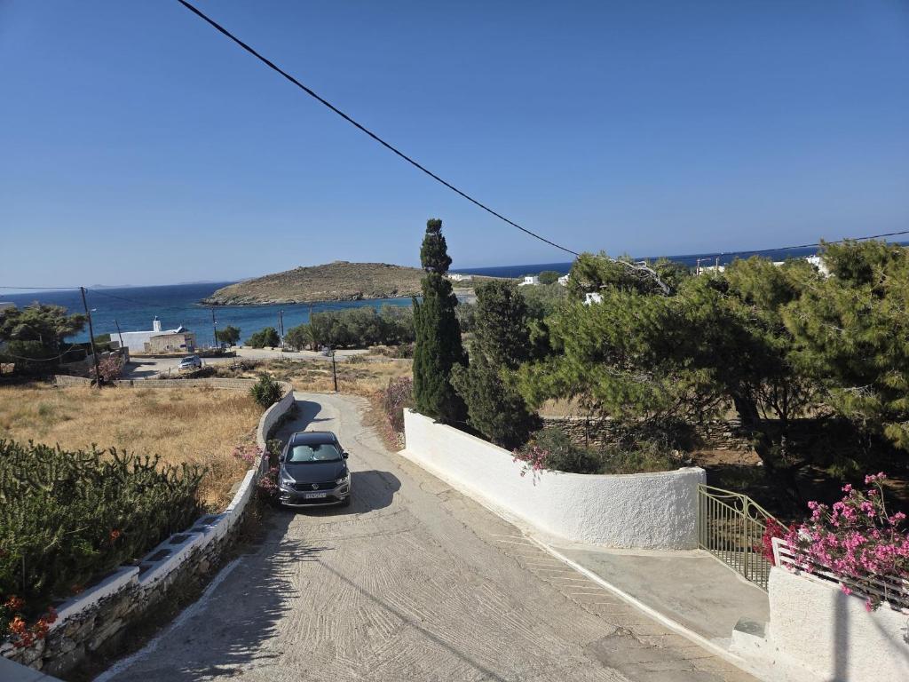 a car parked on a road near the ocean at Aegean Balcony in Tinos