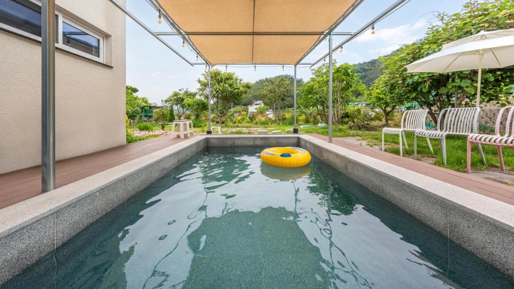 a swimming pool with a yellow ball in the water at Yeosu Everyday Small Changes Pension in Yeosu