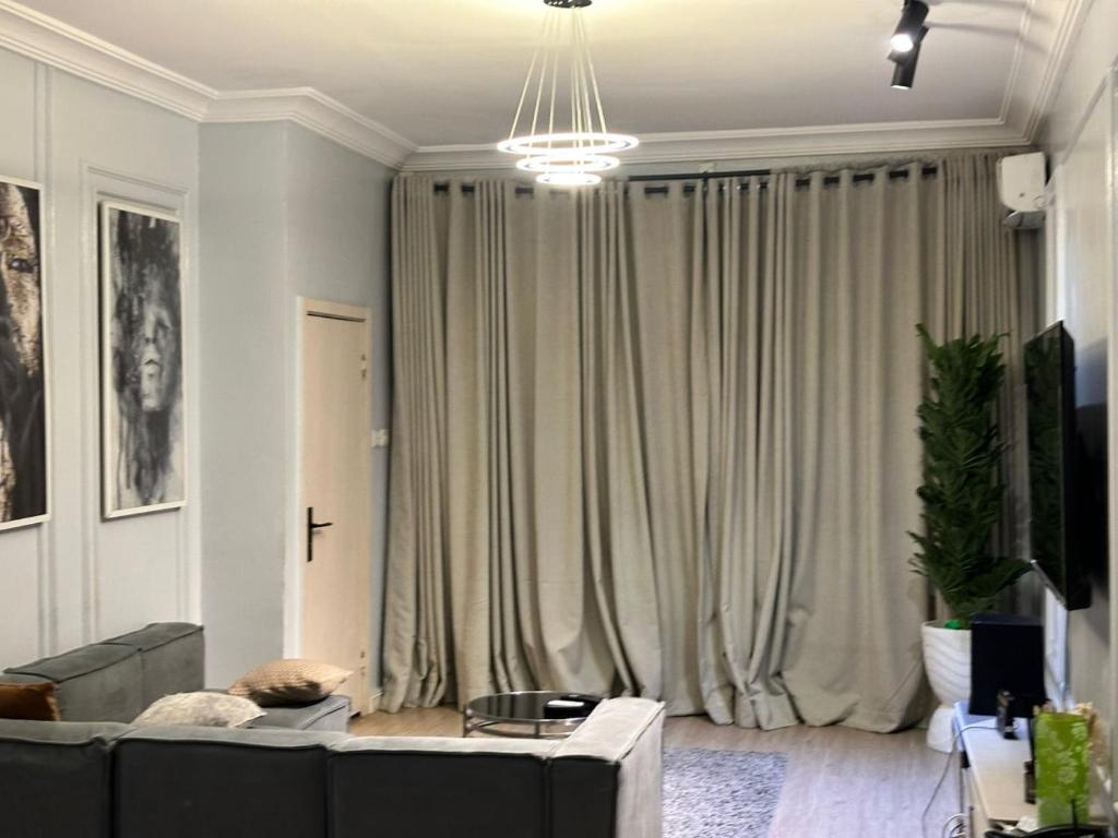 a living room with a couch and a large window at Luimora Stays in Bamgbose