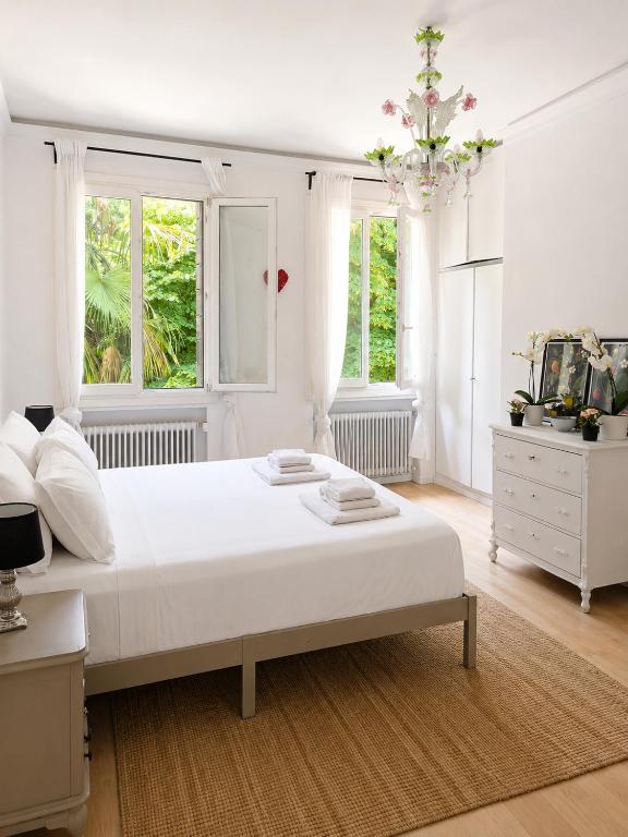 a white bedroom with a large bed and two windows at Garden Lodge by Veneto Villa in Albignasego