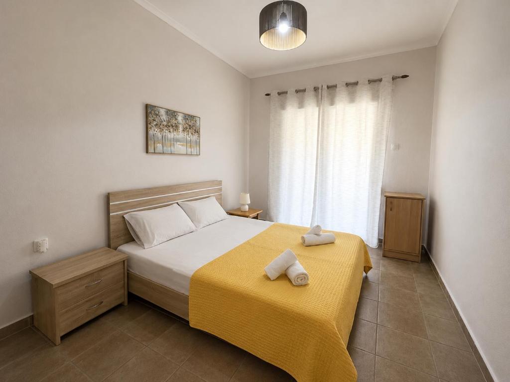 a bedroom with a bed with two towels on it at Otium Apartment in Nea Peramos