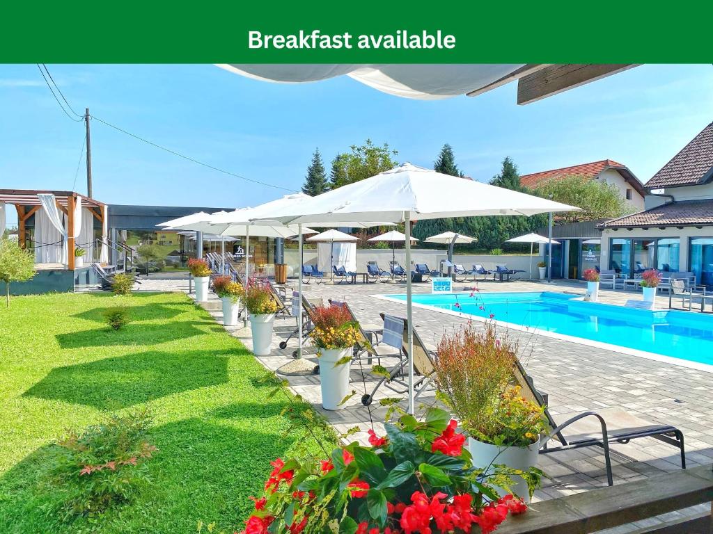 a pool with umbrellas and flowers in a yard at 16 Lakes Guesthouse in Grabovac