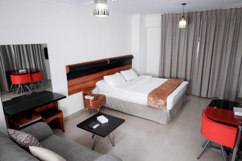 a hotel room with a bed and a couch at The Apartments By Sedrah in Irbid