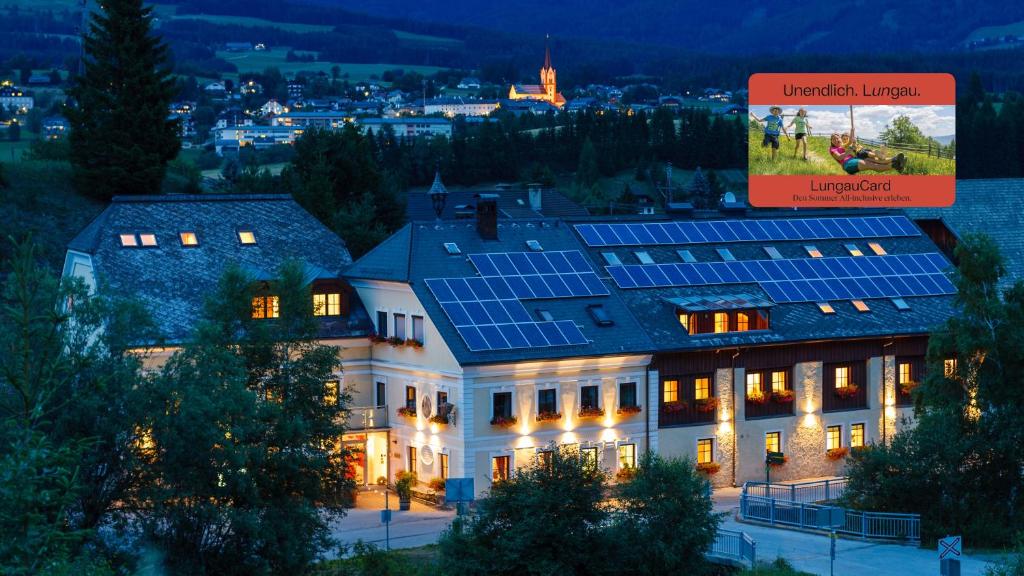 a building with solar panels on the roof at night at Ferienwelt Bogensperger in Mariapfarr