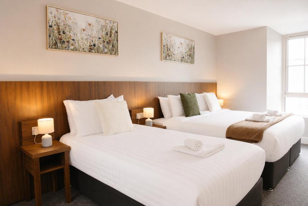 two beds in a hotel room with white sheets at Coach House Accommodation - Room 5 in Carrick on Shannon