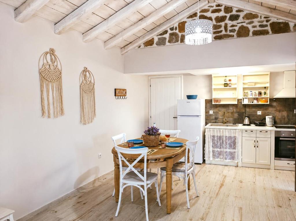 a kitchen with a table and chairs in a room at Paliokaliva Home in Roussopoúlion