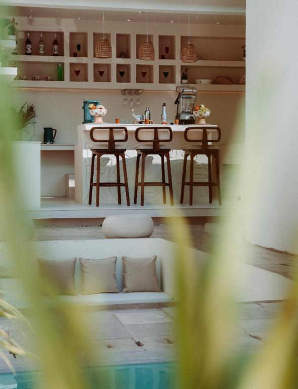 a kitchen with a table and two stools at Salt & Palm Villa in Maggona West