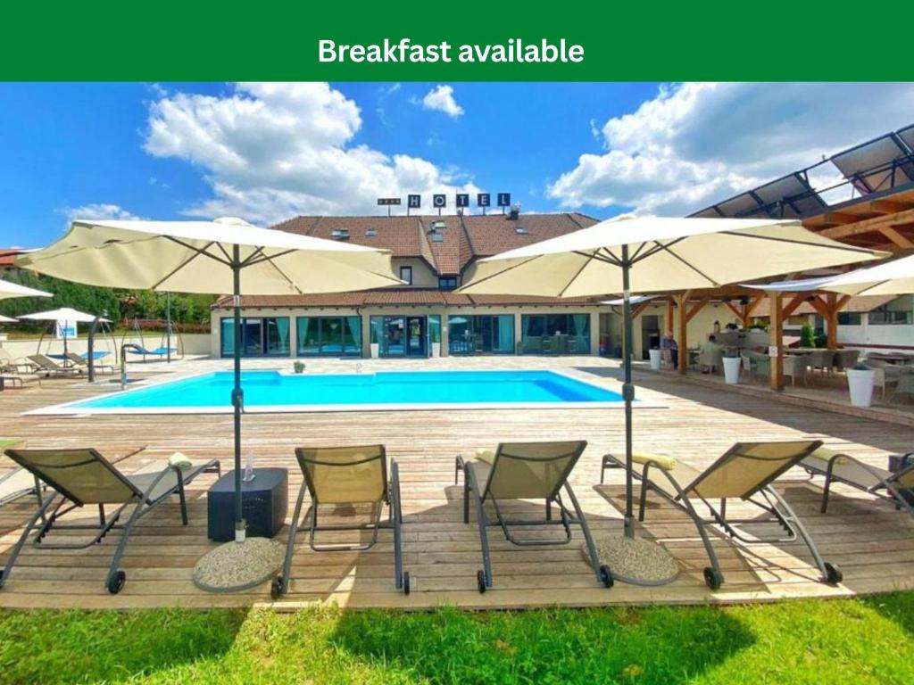 a group of chairs and umbrellas next to a pool at 16 Lakes Hotel in Grabovac