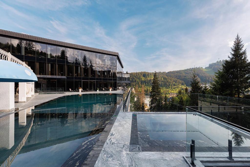 a large building with a swimming pool in front of it at Hotel Podgorie Spa in Bukovel