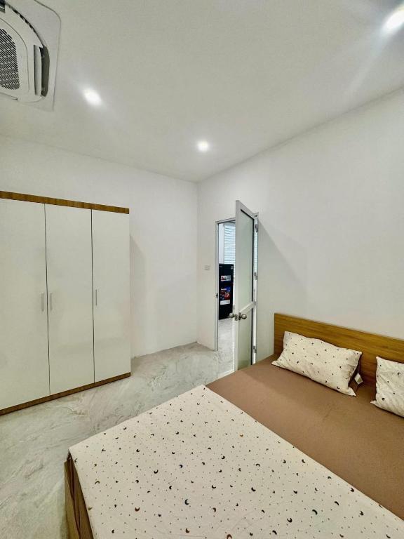 a bedroom with two beds in a room with avertisement at Lumina Haven in Thượng Lôi
