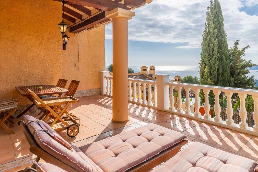 a balcony with chairs and a table on a balcony at Blue Emi Altea Hills in Altea la Vieja