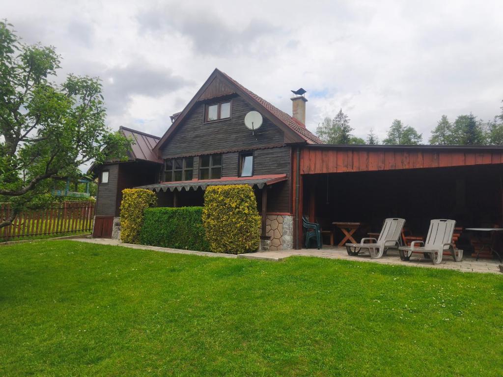 a barn with two chairs and a table in the yard at Chata Vanessa in Stránske