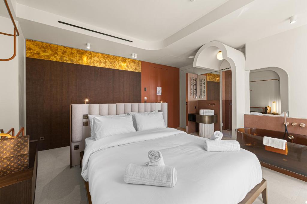a bedroom with a large white bed and a bathroom at Naomi Cannes in Cannes