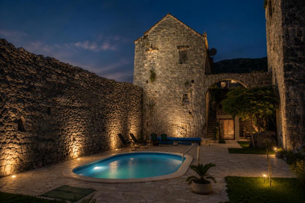 an old building with a swimming pool in a courtyard at Villa Bilja Historic Stone Castle in Trebinje