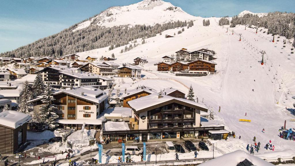 a ski lodge with a snow covered mountain in the background at Hotel Jagdhaus Monzabon in Lech am Arlberg