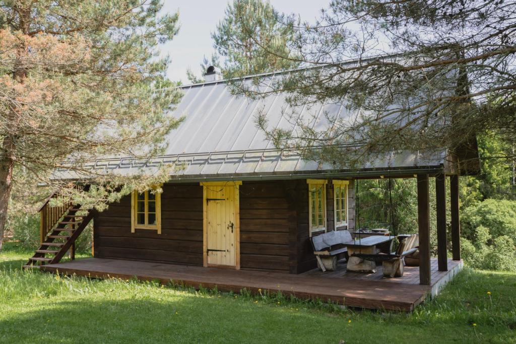 a log cabin with a deck and a table at Sauna house with minilake in Voki