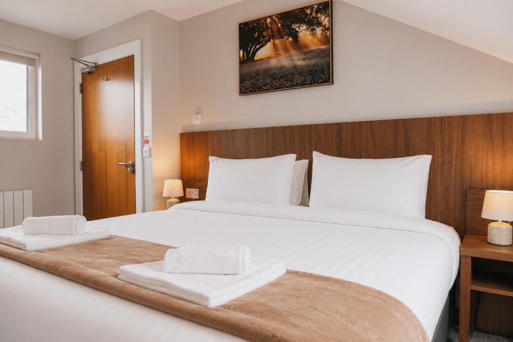 a bedroom with a large white bed with two towels on it at Coach House Accommodation - Room 7 in Carrick on Shannon