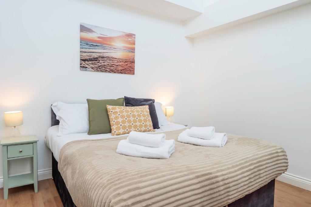 a bedroom with a bed with two towels on it at 4 Bed Contractor Apartment with Parking Central Banbury in Banbury