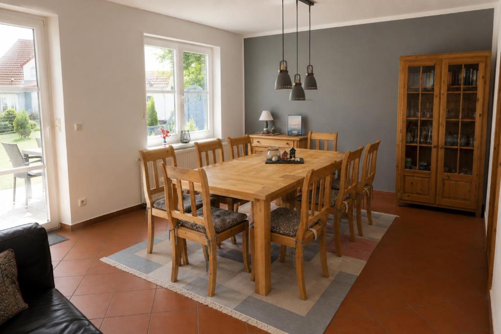 a dining room with a wooden table and chairs at Ferienhaus zum Kranichblick ideal für Familien gern mit Hund in Garz