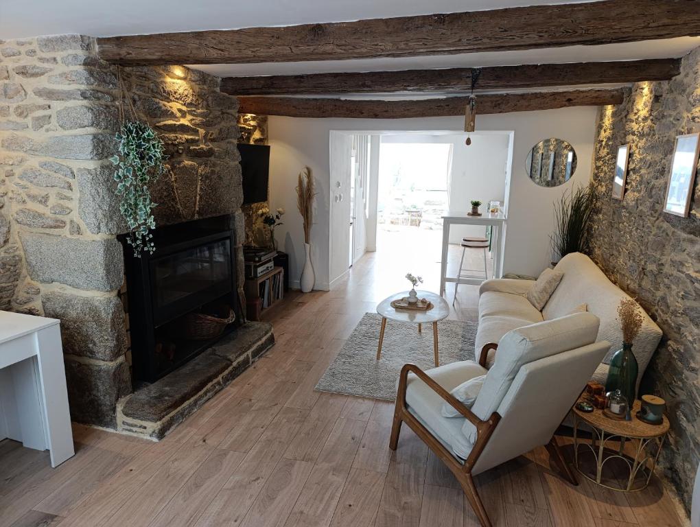 a living room with a couch and a stone fireplace at Village du Manémeur in Quiberon