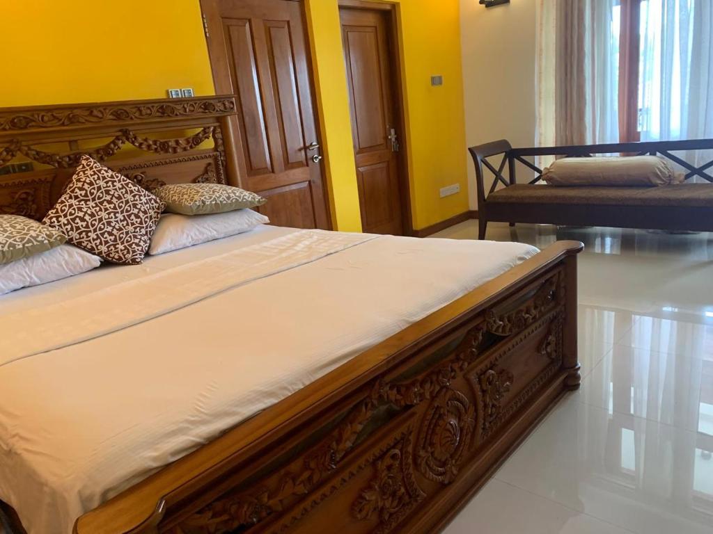 a large bed in a room with yellow walls at Deepa Thamel House in Cotta Road Railroad Station