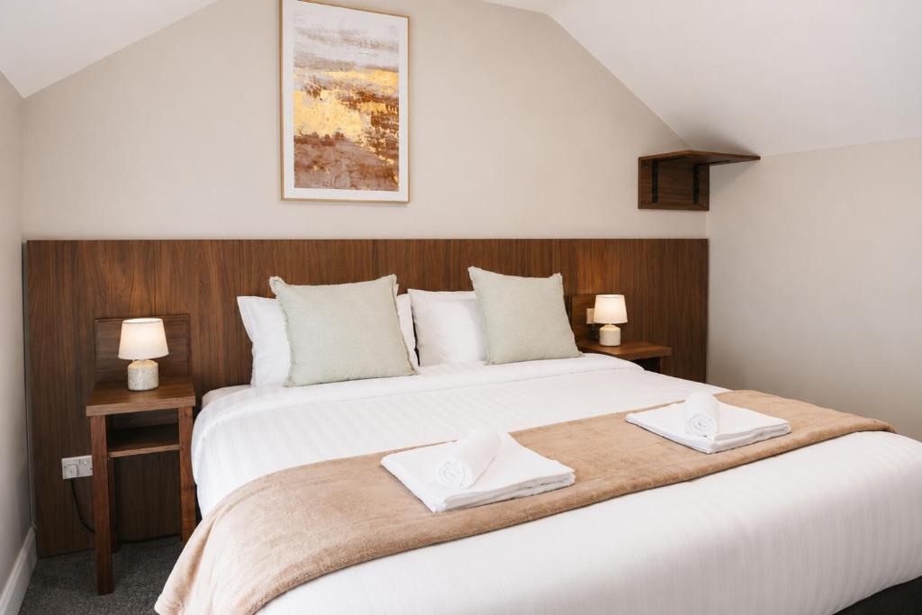 a bedroom with a large bed with two towels on it at Coach House Accommodation - Room 9 in Carrick on Shannon