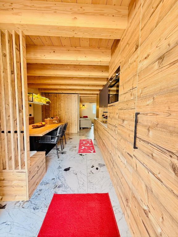 a room with wooden walls and a red carpet at Maso K - Il Gufo Dorato in Folgaria